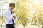 A Young Businessman Is Folding A White Sleeve On His Balcony Stock Photo