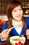 Girl Eating Meatball With Shopstick And Spoon Stock Photo