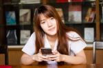 Portrait Of Thai Adult Student University Uniform Beautiful Girl Using Her Smart Phone Stock Photo