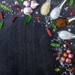 Top View Of Food Ingredients And Condiment On The Table, Ingredients And Seasoning On Dark Wooden Floor Stock Photo