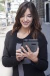 Young Woman Holding A Tablet On The Street Stock Photo