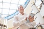 Man With Tablet Computer In Modern Business Building Stock Photo