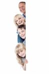 Family Of Four Behind Blank Whiteboard Stock Photo