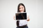 Portrait Of Thai High School Student Uniform Beautiful Girl Using Her Tablet Stock Photo