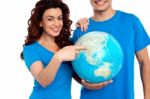 Smiling Young Couple Holding Globe Stock Photo