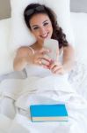 Beautiful Young Woman Using Her Mobile Phone In The Bed Stock Photo