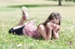 Girl  Laying On Grass Field Stock Photo