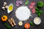 The Ingredients For Homemade Pizza On Dark Stone Background Stock Photo