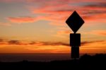 Road Sign Silhouette And Colorful Sunset Stock Photo