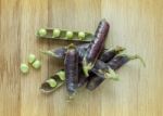 Fresh Violet Peas Isolated On A Wooden Background Stock Photo