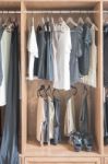 Clothes Hanging In Wooden Wardrobe Stock Photo