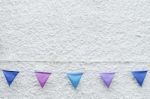 Colorful Party Flags Bunting Hanging On White Wall Background. Minimal Hipster Style Design Stock Photo