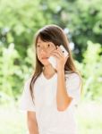 Asia Girl Use Smart Phone In Garden Stock Photo