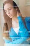 Depressed Young Woman Sitting At Home Stock Photo