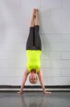 Middle Age Woman Doing Handstand Across Wall Stock Photo