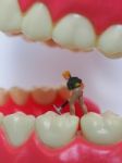 Miniature Worker On Plastic Teeth Of Removable Denture. Dental H Stock Photo