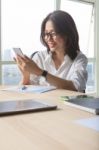 Office Table Scene Of Asian Working Woman Reading Message On Mobile Phone For Modern Life Connecting Stock Photo