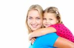 Daughter Enjoying Piggy Ride. Playful Mother Stock Photo