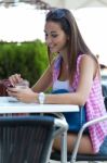 Beautiful Girl Drinking Coffee And Texting With Mobile Phone Stock Photo