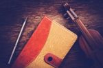 Violin And Notebook With Pen On Grunge Dark Wood Background Stock Photo