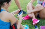 Running Girls Having Fun In The Park With Mobile Phone Stock Photo