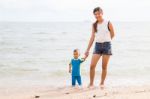 Son And Mom Chill On The Beach Stock Photo