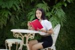 Thai Adult Student University Beautiful Girl Reading Red Book Stock Photo