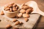 Almond In Wooden Spoon Spilling On Table Stock Photo