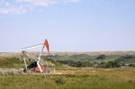 Oil Well In Grassy Field Stock Photo