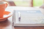 Coffee Cup With Pen And Spiral Notebook Stock Photo