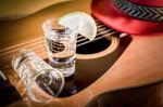 Glass Of Vodka And Classical Guitar With Red Hat Stock Photo