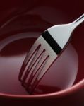 Fork In Dark Red Ceramic Dish Stock Photo