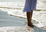 Girl's Legs On The Beach Stock Photo