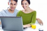 Happy Young Couple Browsing Internet At Home Stock Photo