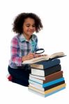 Cute Kid Reading Book With Magnifying Glass Stock Photo