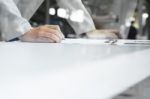 Man Writing On Notebook With Digital Tablet On Wooden Table, Sel Stock Photo