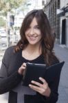 Young Woman Holding A Tablet On The Street Stock Photo