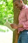 Smiling Man Using Tablet Pc In The Park Stock Photo