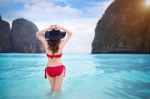 Young Woman In Red Bikini Sitting On The Beach Stock Photo