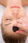 Therapist Placing Stone Woman's Forehead Stock Photo