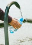 Hand Filling Water Into Bottle Stock Photo