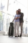 Loving Young Man Embracing Woman At Airport Stock Photo