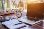 Desktop Mix Of Office Supplies And Gadgets . Desk With Laptop , Smart Phone, Glasses , Watch , Notebook , Tablet, On A Wood Table Stock Photo