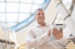 Smiling Businessman With Tablet Computer In Modern Business Buil Stock Photo