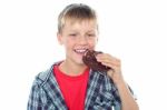 Young Boy Eating Chocolate Cookie Stock Photo