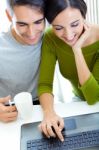 Happy Young Couple Browsing Internet At Home Stock Photo