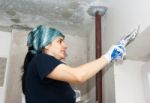 Young Woman Gets Plaster Wall Stock Photo