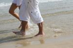 Male And Female Walking At Beach Stock Photo