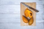 Yellow Egg Fruit On Wood Cutting Board Stock Photo