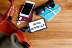 Travel Insurance Tag With Bag On Wood Background Stock Photo